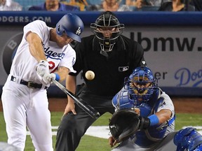Los Angeles Dodgers’ Chase Utley hits an RBI double as Kansas City Royals catcher Salvador Perez, right, and home plate umpire Todd Tichenor watch Friday, July 7, 2017, in Los Angeles. (AP Photo/Mark J. Terrill)