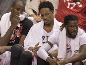 Toronto Raptors' Serge Ibaka, DeMar DeRozan and DeMarre Carroll watch the action from the bench as they take on the Cleveland Cavaliers during Game 3 of an NBA playoff series in Toronto on May 5, 2017. (THE CANADIAN PRESS/Fred Thornhill)