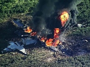 In this Monday, July 10, 2017 frame from video, smoke and flames rise from a military plane that crashed in a farm field, in Itta Bena, Miss., killing several. (WLBT-TV via AP)