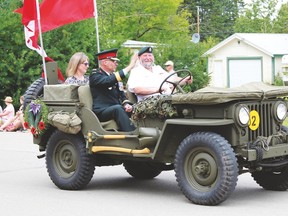 Royal Canadian Legion officer Paul Spurrell had the honour of driving the Parade Marshall, Lieutenent -General Paul F. Wynnyk through the familiar streets of Breton, where he grew up. With them in the back of the jeep is Wynnyk’s wife, Dr. Marianne Howell. (More photos of Breton Parade are on our Facebook page).