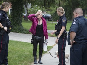 Allison Stacey reacts while speaking with authorities on Tuesday, July 11 after arriving home to discover that firefighters had just put out a fire in the basement of her house. (DEREK RUTTAN, The London Free Press)