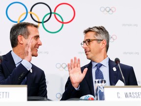 Eric Garcetti, Mayor of Los Angeles, left, and Casey Wasserman, chairman of Los Angeles 2024, right, high five during a press conference at the SwissTech Convention Centre, in Lausanne, Switzerland, Tuesday, July 11, 2017. (Valentin Flauraud/Keystone via AP)