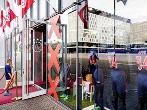 A boy walks into a store next to football jerseys bearing the words 'Stay Strong Appie' and the number 34 to show support to Ajax midfielder Abdelhak Nouri in Amsterdam on July 10, 2017. (AFP PHOTO)