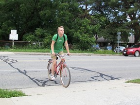 David Jeremiah, 17, crosses Exmouth Street on his bicycle while riding the Howard Watson Nature Trail Tuesday. The City of Sarnia is considering a stoplight-guarded crosswalk for the intersection. (Tyler Kula/Sarnia Observer)