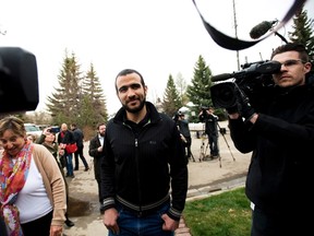 Omar Khadr walks back to his home after speaking to the media after being granted bail in Edmonton on Thursday, May 7, 2015. THE CANADIAN PRESS/Nathan Denette