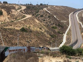 Partial view of the US-Mexico border wall painted by members of the Brotherhood Mural organization in Tijuana, Mexico on July 6, 2017. GUILLERMO ARIAS/AFP/Getty Images