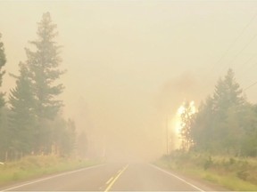 A wildfire burns by the side of the highway in British Columbia's West Chilcotin region in this handout photo taken from video. (Twitter/Sally Aitken)