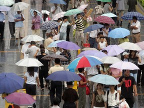 Beijing residents carry umbrellas as they head to work in this file photo.  (STR/AFP/Getty Images)