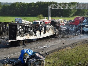 Investigators survey the scene of a multi-vehicle accident that claimed multiple lives on Tuesday, July 11, 2017, on westbound Interstate 70 just west of Bonner Springs, Kans. The crash closed the highway in both directions for about two hours. (Keith Myers/The Kansas City Star via AP)