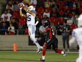 Toronto Argonauts wide receiver DeVier Posey catches the ball in the end zone for a touchdown as Ottawa Redblacks defensive back Nicholas Taylor looks on during CFL action in Ottawa on July 8, 2017. (THE CANADIAN PRESS/Patrick Doyle)
