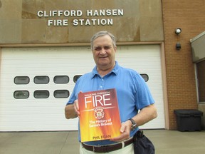 Sarnia author Phil Egan stands outside the East Street fire hall Wednesday July 12, 2017 in Sarnia, Ont., holding a mock up of the cover of Walking Through Fire: The History of Sarnia's Bravest, his new book about the 177-year history of the city's fire service, published by the Sarnia Historical Society.  A book signing event is being held Saturday, 10 a.m. to 3 p.m., at the fire hall where the service's new inflatable fire safety house will also be shown to the public. (Paul Morden/Sarnia Observer)