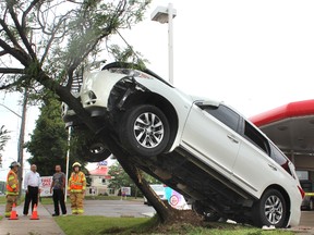 Two people were taken to hospital for observation after an SUV struck a tree at the Petro-Canada gas station at Wellington and Exeter roads in London Wednesday afternoon. (DALE CARRUTHERS, The London Free Press)