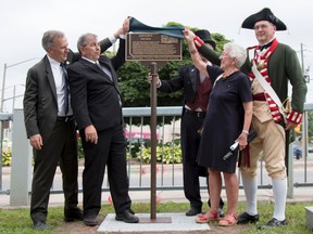 Taylor Bertelink/the Intelligencer
(Left to right) Neil Ellis, Garnet Thompson, Richard Hughes, Lois Foster and Douglas Knutson reveal the plaque commemorating the historical significance of Simpson's Tavern on Wednesday.