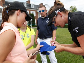 Brittany Lang signs a hat for a fan during a practice round for the U.S. Open at Trump National Golf Club in Bedminster, N.J., on July 12, 2017. (AP Photo/Seth Wenig)