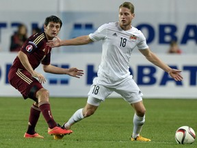 Russia's midfielder Denis Cheryshev vies for the ball with Liechtenstein's midfielder Nicolas Hasler, right, during the UEFA Euro 2016 qualifying football match between Russia and Liechtenstein in Moscow on Sept. 8, 2014. (AFP PHOTO/ALEXANDER NEMENOV)