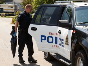 An Edmonton Police Service officer removes an item from a mobile home as he and other officers investigate an overnight aggravated assault in the Evergreen Community in Edmonton on Thursday, July 13, 2017. Ian Kucerak / Postmedia