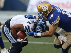 Toronto running back Brandon Whitaker (left) is tackled by Blue Bombers defender Taylor Loffler, who had a strong game. Kevin King/Postmedia Network
