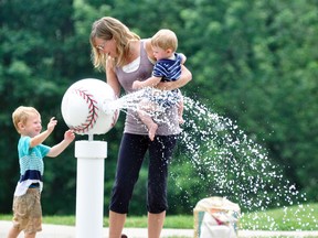 Ashley Pennings and her two sons, Aiden (left), 3 and Carson, 11-months, spent some time last Wednesday, July 12 at the West Perth Lions Pool splash pad finding a way to beat the heat.  ANDY BADER/MITCHELL ADVOCATE