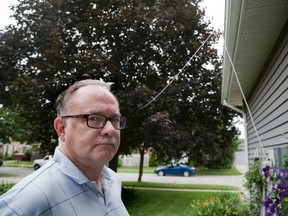 Television/intenet cable installed by Rogers runs from David Stanford's home through his eavestrough, four trees and street light to a cable box on his neighbour's lawn three houses away. (DEREK RUTTAN, The London Free Press)