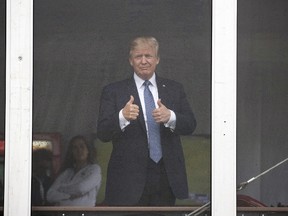 President Donald Trump gives the thumbs-up as the look the the crowd from his viewing stand, Friday, July 14, 2017, during the U.S. Women's Open Golf tournament at Trump National Golf Club in Bedminster, N.J. (AP Photo/Carolyn Kaster)