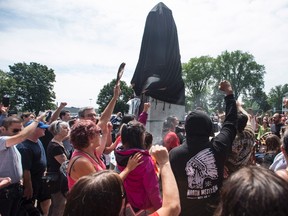 Activists protest at the base of the Edward Cornwallis statue after city staff covered it with a black sheet in Cornwallis Park in Halifax on Saturday, July 15, 2017. Protesters who pledged to remove a statue of Halifax's controversial founder Saturday say they came away victorious after the monument to Edward Cornwallis was covered in a tarp. THE CANADIAN PRESS/Darren Calabrese