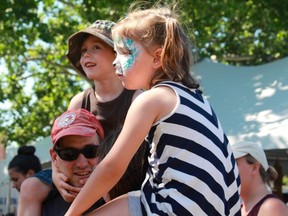 Charlie (6) and Gemma (5) Gould hang out with their parents, Ryan Gould and Nikki Favalaro near the children's stage at Home County Music and Art Festival on Saturday, Jul. 15 (Shalu Mehta/The London Free Press).