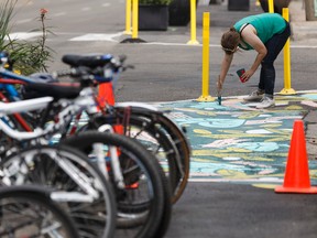 Artist Jill Stanton paints in Jasper Avenue as pedestrians walk by during the Experience Jasper Avenue event in Edmonton on Saturday, July 15, 2017. Ian Kucerak / Postmedia