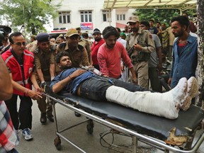 An Indian Hindu pilgrim injured in a bus accident is brought for treatment at a hospital in Jammu, India, Sunday, July 16, 2017. A bus plunged into a 45-meter-deep (150-foot-deep) gorge in the Indian portion of Kashmir on Sunday, killing at least 16 Hindu pilgrims on their way to a cave shrine in the Himalayas. (AP Photo/Channi Anand)