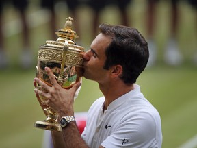 Switzerland's Roger Federer celebrates with the trophy after beating Croatia's Marin Cilic in the Men's Singles final match on day thirteen at the Wimbledon Tennis Championships in London Sunday, July 16, 2017. (AP Photo/Tim Ireland)