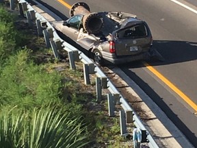 In this photo provided by the Florida Highway Patrol, a van is shown with a piece of scrap metal on its roof in Orange County, Florida, on Saturday, July 15, 2017. The highway patrol said the scrap metal fell from a truck that had lost control and overturned on an overpass. The van driver and the driver of the semi had only minor injuries. (Florida Highway Patrol via AP)