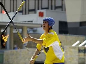 Street performer Paz juggles some flaming hockey sticks at the 2017 Edmonton International Street Performers Festival in Churchill Square on July 13, 2017. Photo by Larry Wong