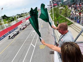 Honorary starters Richard and Rebecca Wilson waves green flags to start the Honda Indy Toronto in Toronto on Sunday, July 16, 2017. (THE CANADIAN PRESS/Frank Gunn)