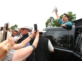Prime Minister Justin Trudeau waves goodbye with a cowboy salute during a stop at Parkdale Community Association for a pancake breakfast in Calgary, AB on Saturday July 15, 2017. Jim Wells/Postmedia Network