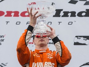 Josef Newgarden lifts a vase on the podium after winning the Honda Indy Toronto in Toronto on Sunday, July 16, 2017. (THE CANADIAN PRESS/Chris Young)