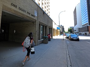 A pedestrian walks in front of a vacant Manitoba Housing building at 185 Smith St., in downtown Winnipeg on Sun., July 16, 2017. The province is expected to announce later this week that it is selling the property. Kevin King/Winnipeg Sun/Postmedia Network