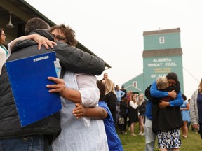 Daughter Stacey Worsfold (in white) hugs a supporter during a memorial for Ron Worsfold at the St. Albert Grain Elevator Park in St. Albert on Sunday, July 16, 2017. Worsfold was killed in a homicide. Ian Kucerak / Postmedia