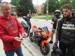 Longtime London motorcyclist Jamie Leslie, left, and Ken Pucula examine a clutch lever found at the scene of London?s latest motorcycle fatality on Ridout Street in London Monday. Jake Timmerman, 17, was killed after his bike struck a utility pole near Bruce Street early Sunday. (MIKE HENSEN, The London Free Press)