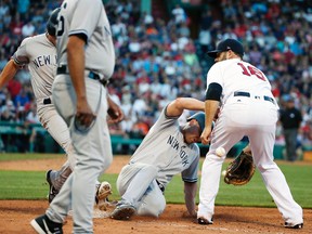 In this Saturday, July 15, 2017 photo, Yankees' Matt Holliday (centre) retreats to first base and Jacoby Ellsbury arrives on a ground ball as the throw from second base bounces off Ellsbury past Red Sox's Mitch Moreland (18) during 11th inning MLB action in Boston. (Michael Dwyer/AP Photo)