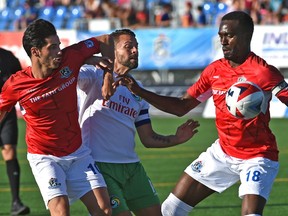 FC Edmonton Mauro Eustaquio (10)  and Tomi Ameobi (18) teamup on New York Cosmos Daniel Szetela (14) during NASL action at Clarke Stadium in Edmonton, July 15, 2017.