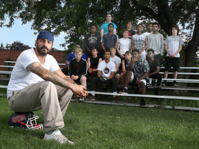 Geoff Woodhouse, president of North Gloucester Giants, poses for a photo with his Giants football team on Monday. About six weeks ago, someone broke into the field house that is the HQ for the North Gloucester Giants football team. They vandalized the place and stole about $17,000 worth of equipment. TONY CALDWELL