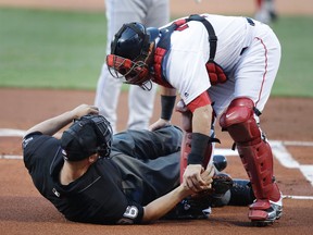 Red Sox catcher Christian Vazquez aids home plate umpire Chris Segal after he was accidentally hit on the head by Blue Jays' Josh Donaldson's bat during the first inning at Fenway Park in Boston on Monday, July 17, 2017. (Charles Krupa/AP Photo)