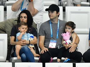 Mila Kunis, left, and her husband US actor Ashton Kutcher, center, are seen with their children during the women's 3m synchro springboard final of the 17th FINA Swimming World Championships in Duna Arena in Budapest, Hungary, Monday, July 17, 2017. (Tibor Illyes/MTI via AP)