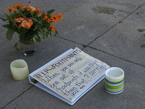 A small shrine is seen on St. Mary Avenue west of Carleton Street in Winnipeg on Tues., July 18, 2017, after a crash there on Monday afternoon claimed the life of a pedestrian. Kevin King/Winnipeg Sun