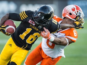 Tiger-Cats' Brandon Banks (left) pushes off of Lions defensive back T.J. Lee (right) during first half CFL action in Hamilton, Ont., on Saturday, July 15, 2017. (Peter Power/The Canadian Press)