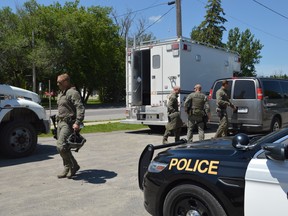 Members of the OPP's tactics and rescue unit unload gear outside the West Nipissing Police sub-office in Verner on Tuesday afternoon. Both police services were engaged in a standoff with a homeowner who would not comply with a property-related order. (Jim Moodie/Sudbury Star)