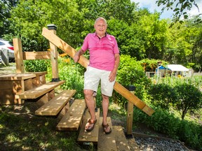 Adi Astl poses for a photo at the top of the staircase he built leading down to Tom Riley Park, near Islington Ave. and Bloor St. W., in Toronto, Ont. on Tuesday July 18, 2017. Ernest Doroszuk/Toronto Sun