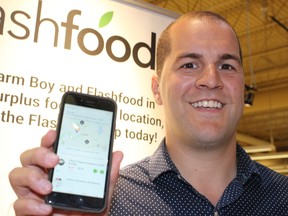 Josh Domingues, founder and CEO of Flashfood, shows off the company's mobile app at its partnership announcement at Farm Boy in West London Tuesday. (CHARLIE PINKERTON, The London Free Press)