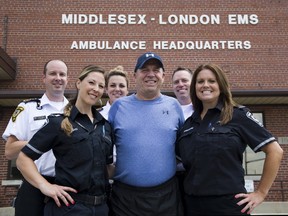 Mike Galbraith, whose life was saved with the help of an automated electronic defibrillator in the Dorchester arena, is donating $2,000 to Middlesex-London EMS for the purchase of another AED. He?s flanked by paramedics Jay Loosley, left, Dawn Bowman, Miranda Bothwell, Steve Cook and Janis Harrison. (Derek Ruttan/The London Free Press)