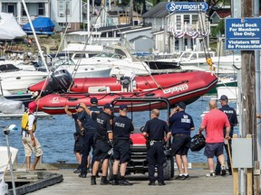 A red rescue boat is hauled out of the water by the Suffolk County Police at the Centerport Yacht Club on Tuesday, July 18, 2017, in Centerport, N.Y. A 10-year-old boy was killed when he fell off a boat and was struck by a propeller while taking sailing lessons on New York's Long Island. Police say it happened after the sailboat he and two others were in was intentionally capsized as part of the lesson. An instructor pulled the boy into an adjacent motor boat, but he then fell out of that boat and was struck by the boat's propeller. (John Paraskevas/Newsday via AP)