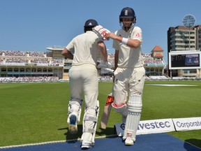 England’s Jonny Barstow heads out to bat as captain Joe Root (right) leaves the field after being bowled out by South Africa. (Getty Images)
